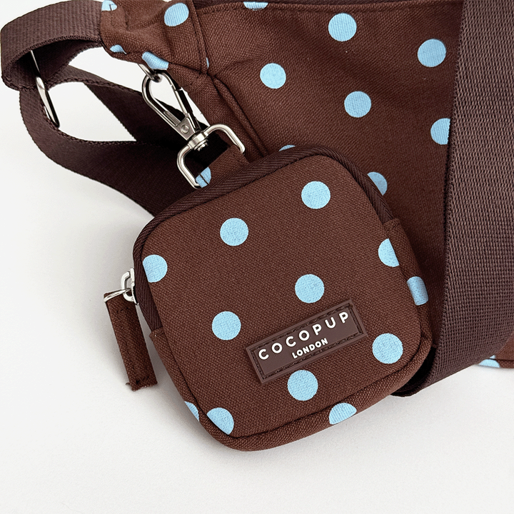 A brown fabric treat pouch with a light blue polka dot pattern. Featuring Cocopup London logo badge and plain brown strap.