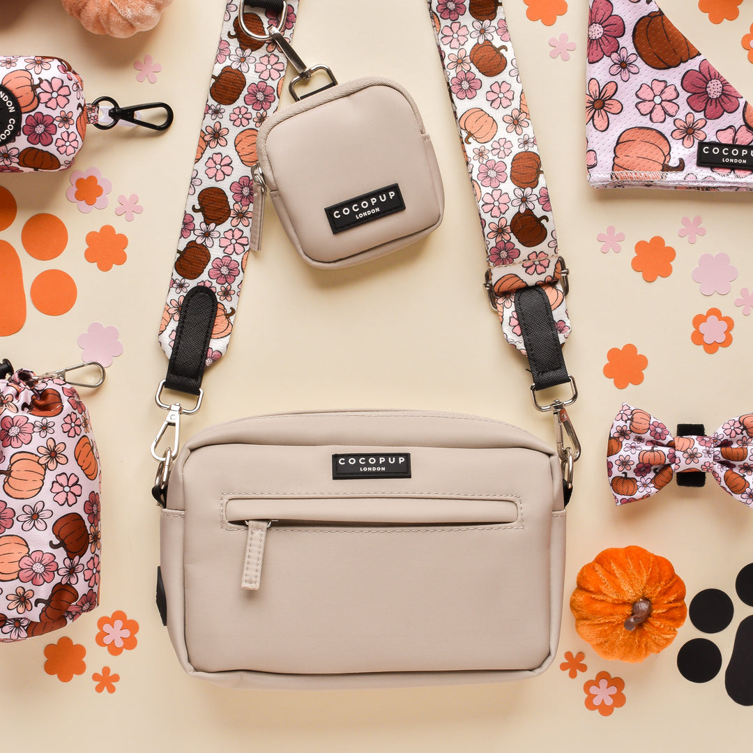 A bag and purse rest on the table, perfect for autumn strolls through Pup-kin Meadow, doubling up as your stylish Dog Walking Bag from Cocopup London featuring the charming Bag Strap - Pup-kin Meadow.