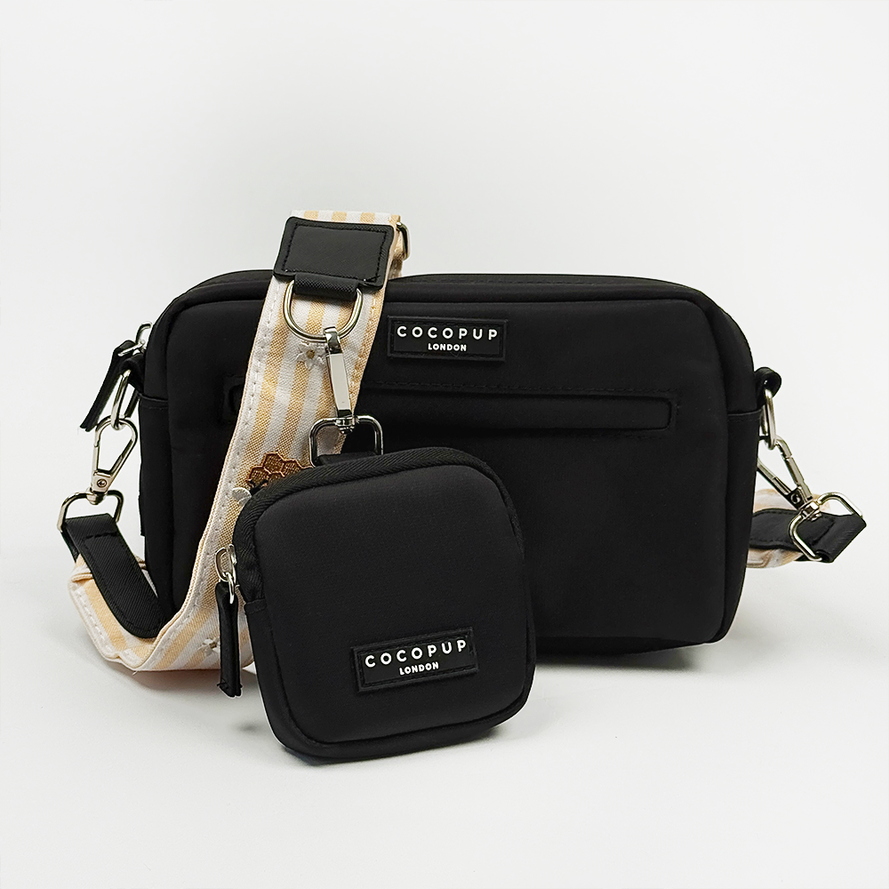 Cocopup black Dog Walking Bag with pale yellow and white striped Bag Strap with bee and honeycomb embroidered decals. Attached is a Cocopup Treat Pouch in black.