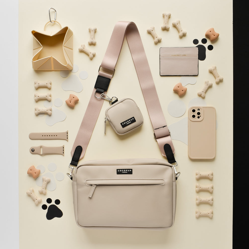 Cocopup London Large Dog Walking Bag in Caramel Latte with treats and accessories on a cream and black surface.
